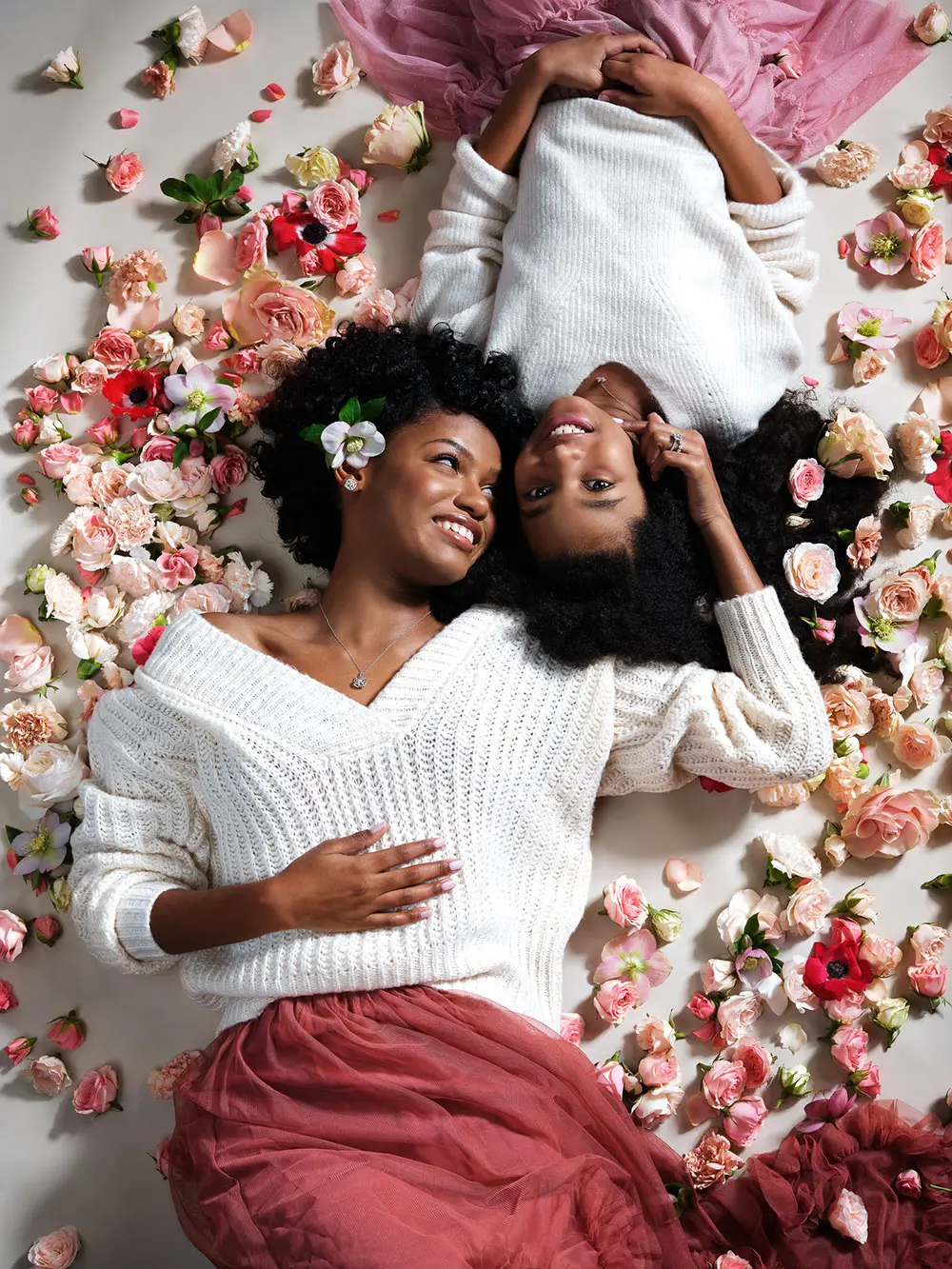 two women laying among flowers