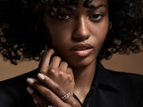 Curly hair person modeling rings with folded hands