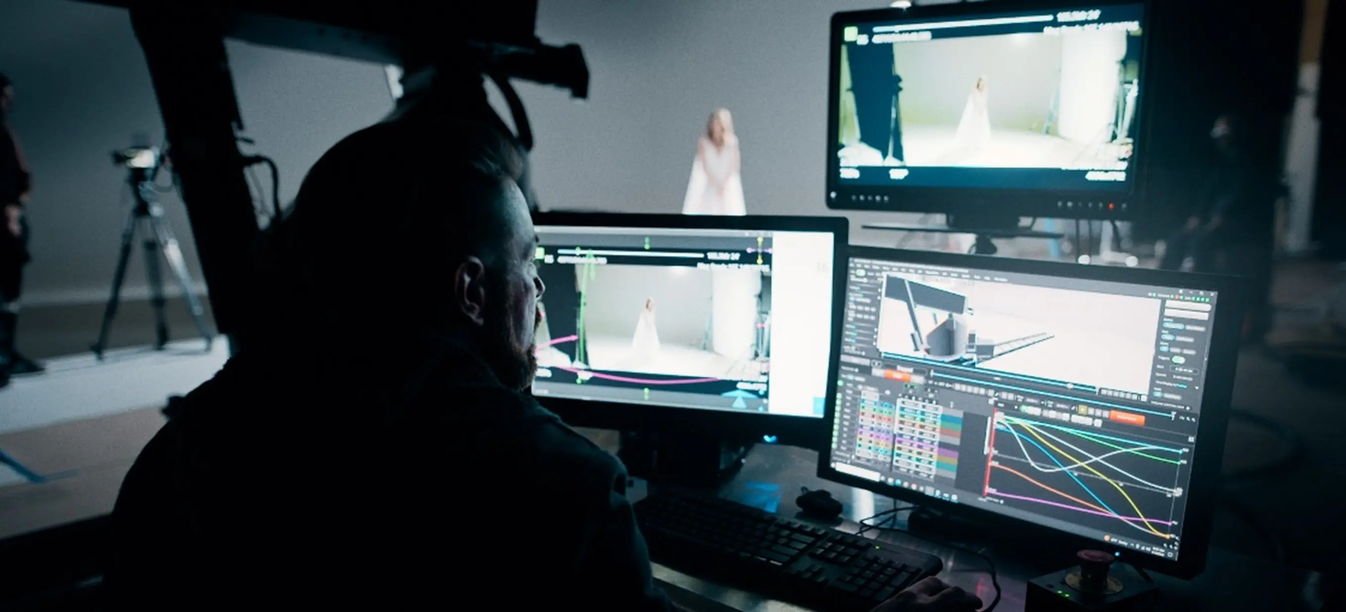 person sitting in front of 3 monitors