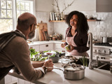 woman talking to man in kitchen as she prepares meal