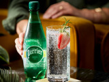Perrier bottle with strawberry in glass