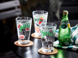 Three glasses with fruit and a bottle of Perrier