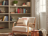 white chair in beige living rom with shelves